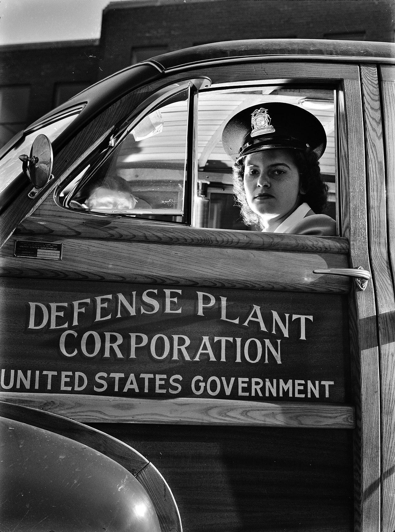 Female driver in uniform sitting in a Defense Plant Corporation vehicle, shuttling workers between two war plants in Milwaukee, Wisconsin